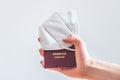 Passport pandemic vacation concept: Close up of fingers holding a passport, ffp2 protection mask, Ã¢â¬ÅReisepass Passport